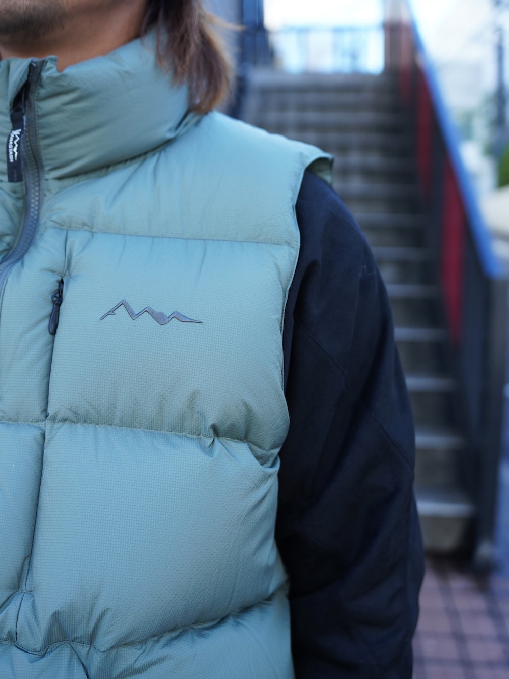 グレー系のスウェットパンツ、グリーン系のダウンベスト、ブラック系のブルゾンを着用したメンズの冬コーディネートの8枚目の写真