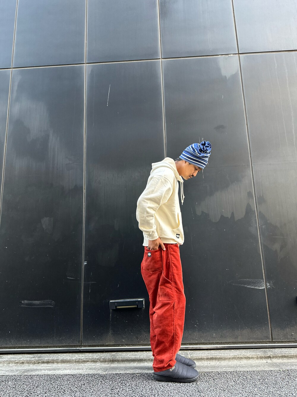 ベージュ系のパーカー、オレンジ系のその他パンツ、ブラック系のスリッポンを着用したメンズの秋コーディネートの2枚目の写真