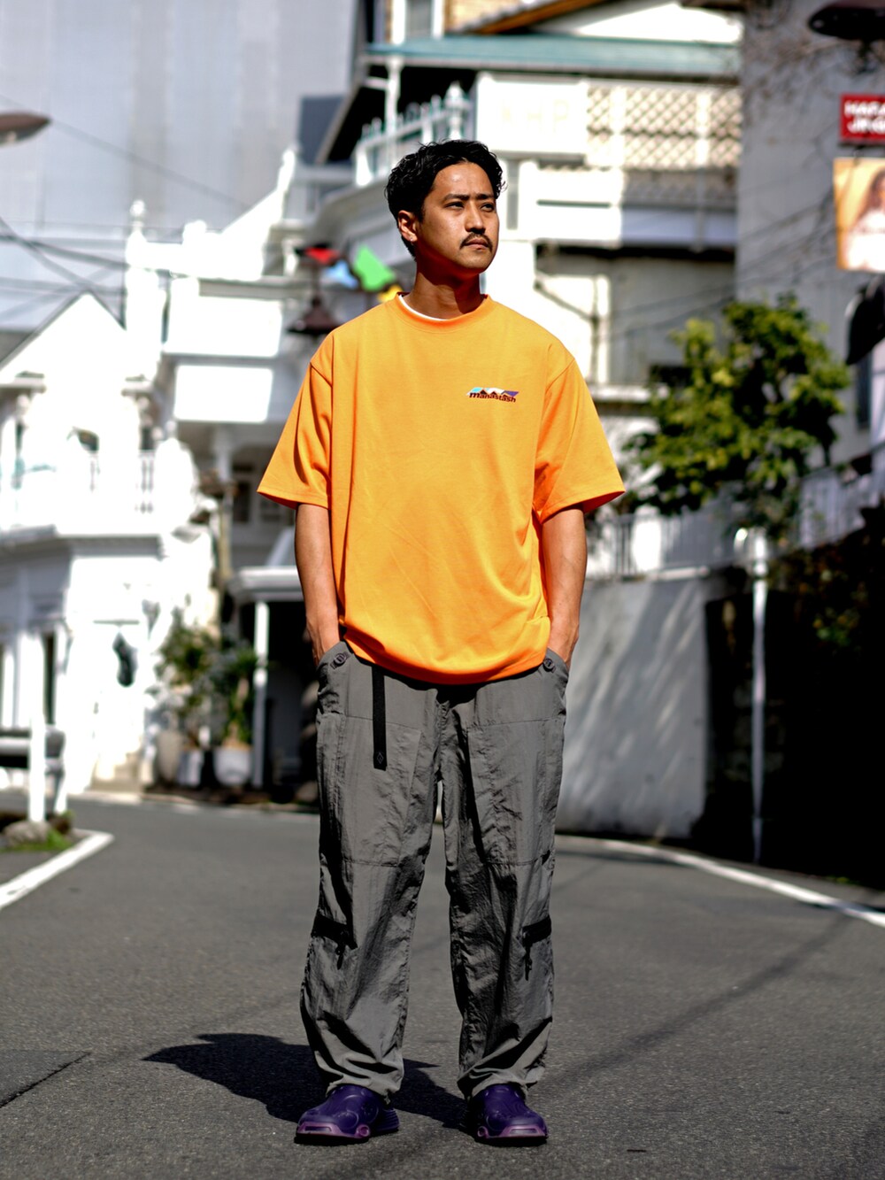 オレンジ系のTシャツ/カットソー、グレー系のその他パンツを着用したメンズの冬コーディネートの5枚目の写真