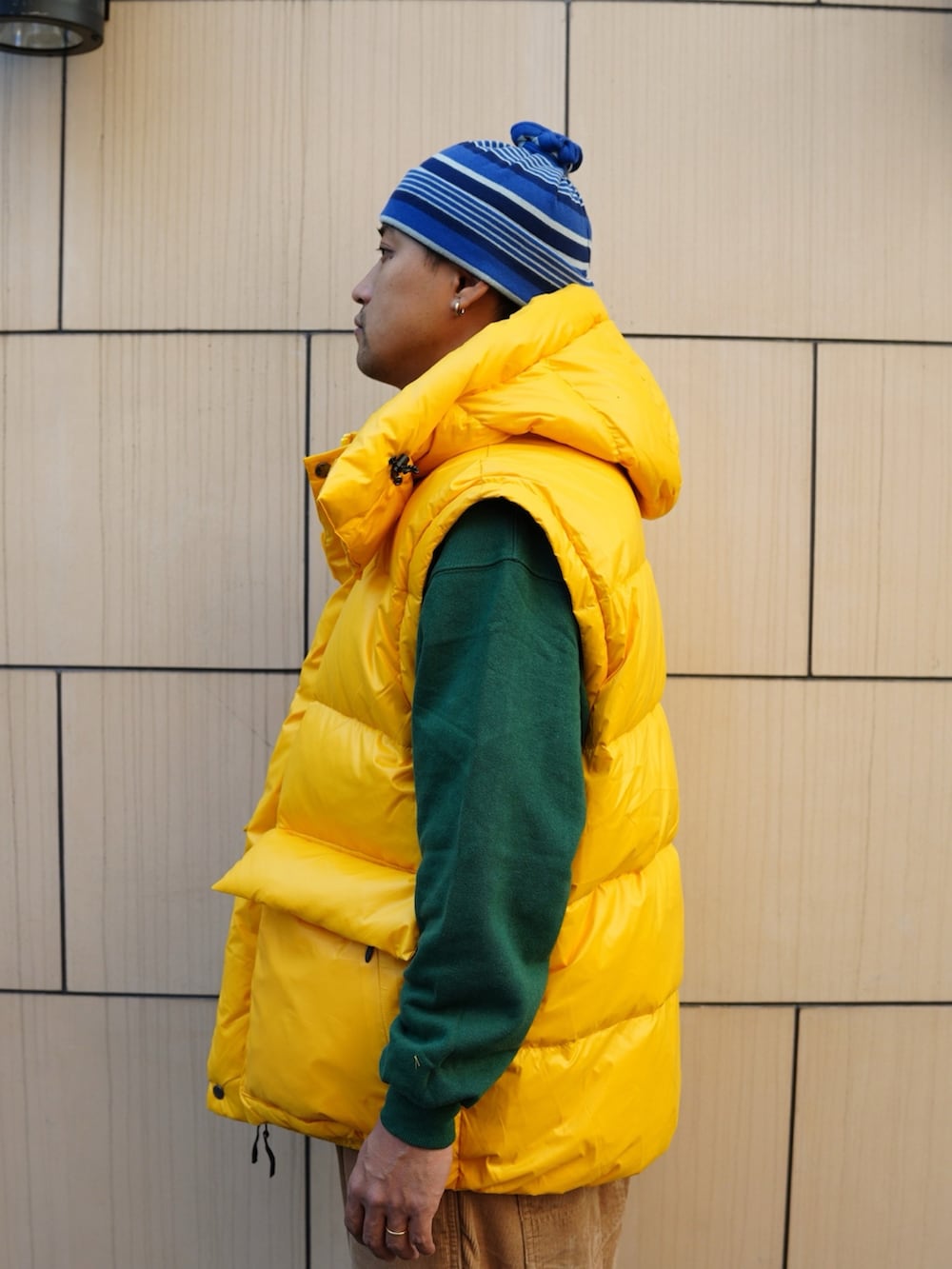 ベージュ系のその他パンツ、イエロー系のダウンジャケット/コート、グリーン系のスウェットを着用したメンズの冬コーディネートの2枚目の写真