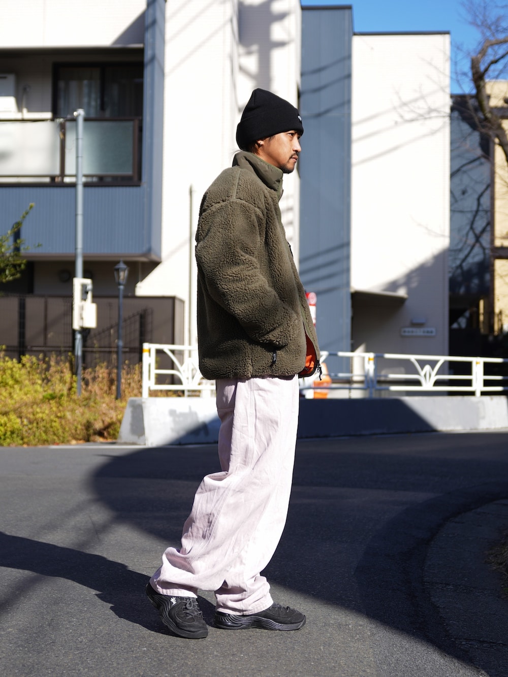 グリーン系のブルゾン、ブラック系のニット/セーターを着用したメンズの冬コーディネートの2枚目の写真