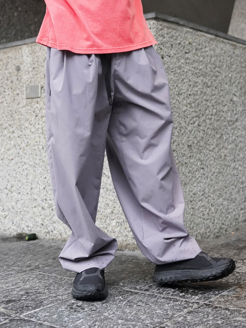レッド系のTシャツ/カットソー、グレー系のその他パンツ、グレー系のサングラスを着用したメンズの夏コーディネートの3枚目の写真
