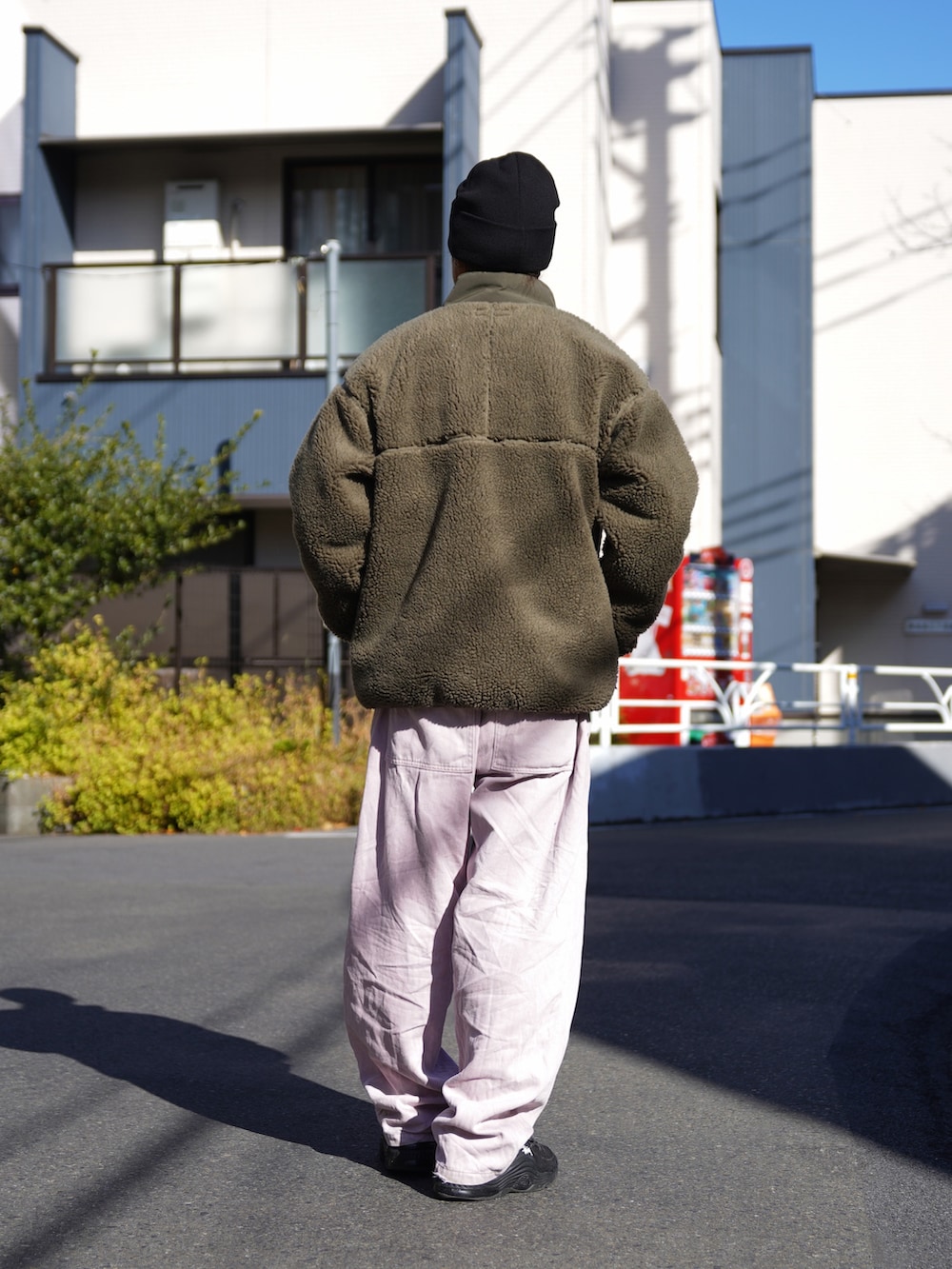 グリーン系のブルゾン、ブラック系のニット/セーターを着用したメンズの冬コーディネートの3枚目の写真