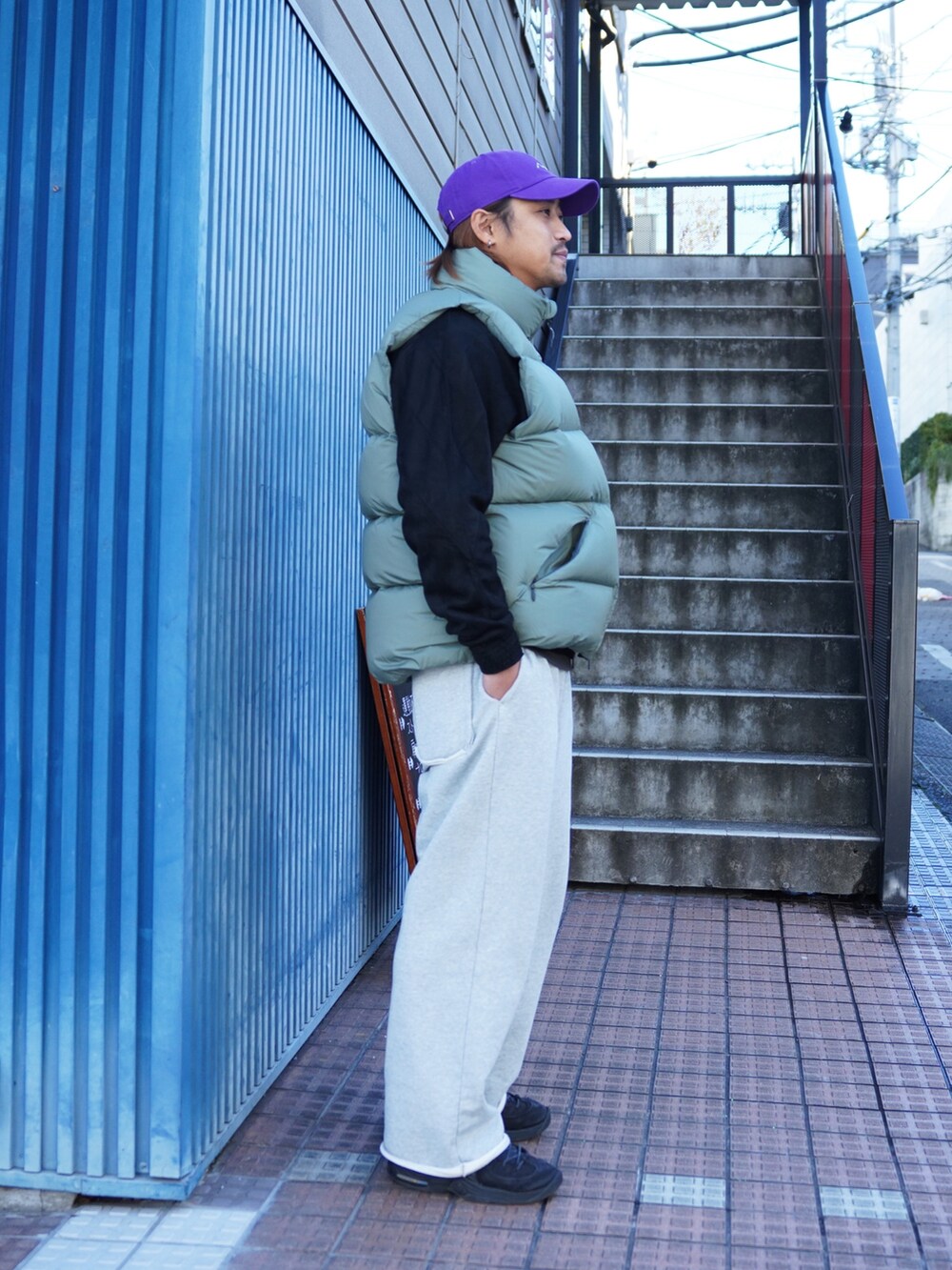 グレー系のスウェットパンツ、グリーン系のダウンベスト、ブラック系のブルゾンを着用したメンズの冬コーディネートの2枚目の写真