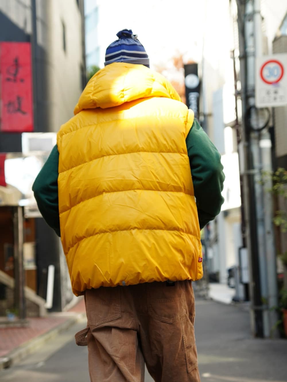 ベージュ系のその他パンツ、イエロー系のダウンジャケット/コート、グリーン系のスウェットを着用したメンズの冬コーディネートの3枚目の写真