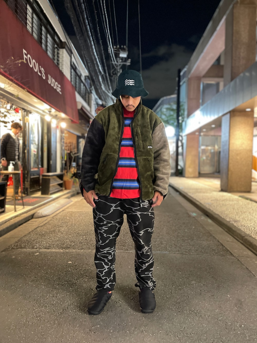 ブラック系のスリッポン、ブラック系のスウェットパンツ、その他のブルゾンを着用したメンズの秋コーディネートの2枚目の写真