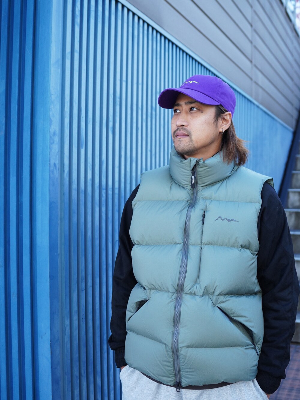 グレー系のスウェットパンツ、グリーン系のダウンベスト、ブラック系のブルゾンを着用したメンズの冬コーディネートの6枚目の写真