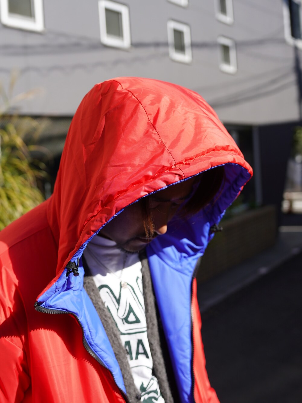 ブルー系のブルゾン、グレー系のカーディガン/ボレロ、レッド系のその他パンツを着用したメンズの冬コーディネートの3枚目の写真