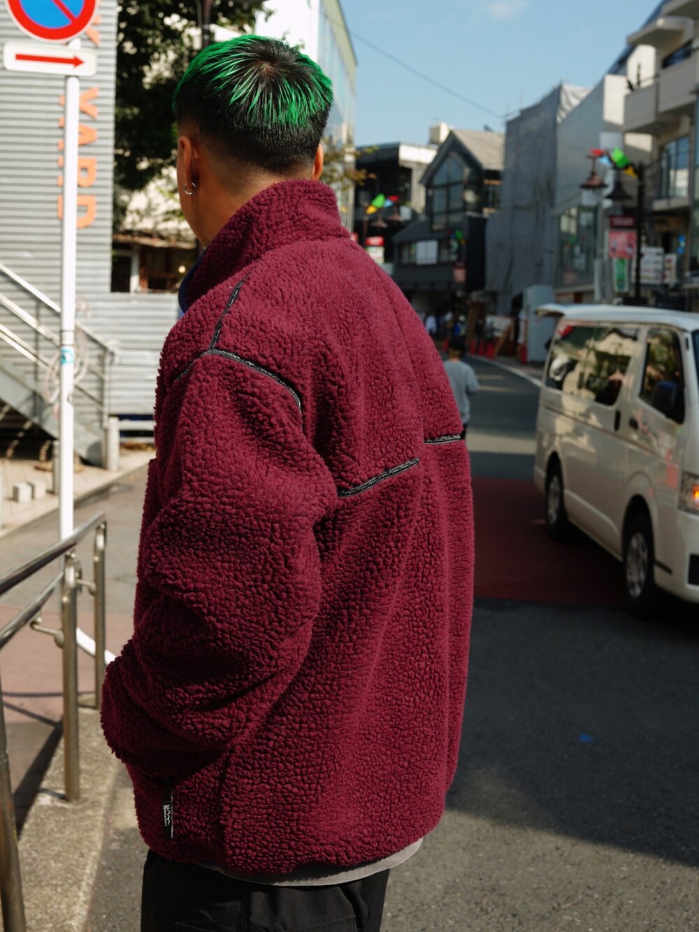 レッド系のブルゾン、グレー系のTシャツ/カットソー、ブラック系のカーゴパンツを着用したメンズの秋コーディネートの2枚目の写真