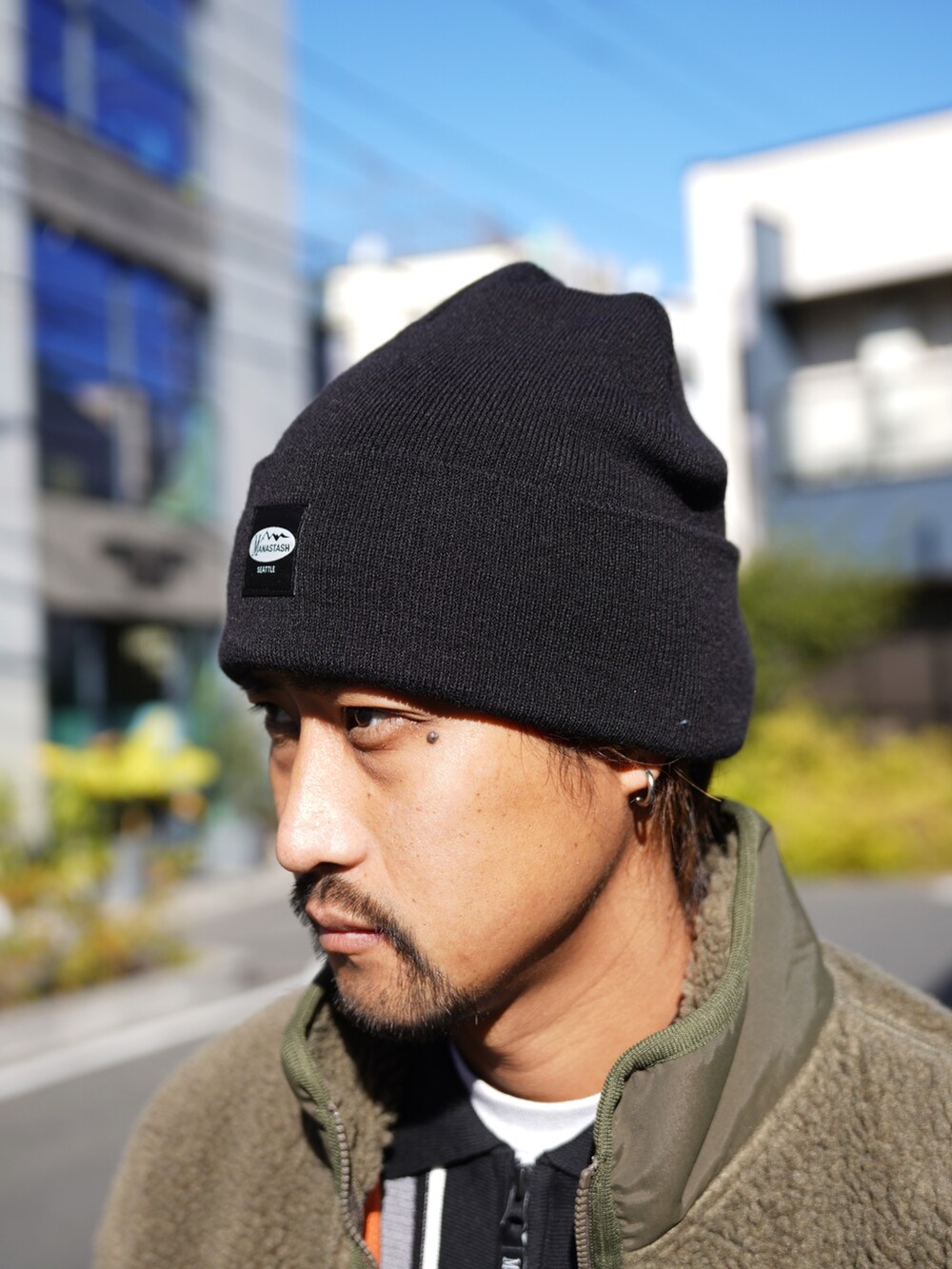 グリーン系のブルゾン、ブラック系のニット/セーターを着用したメンズの冬コーディネートの8枚目の写真