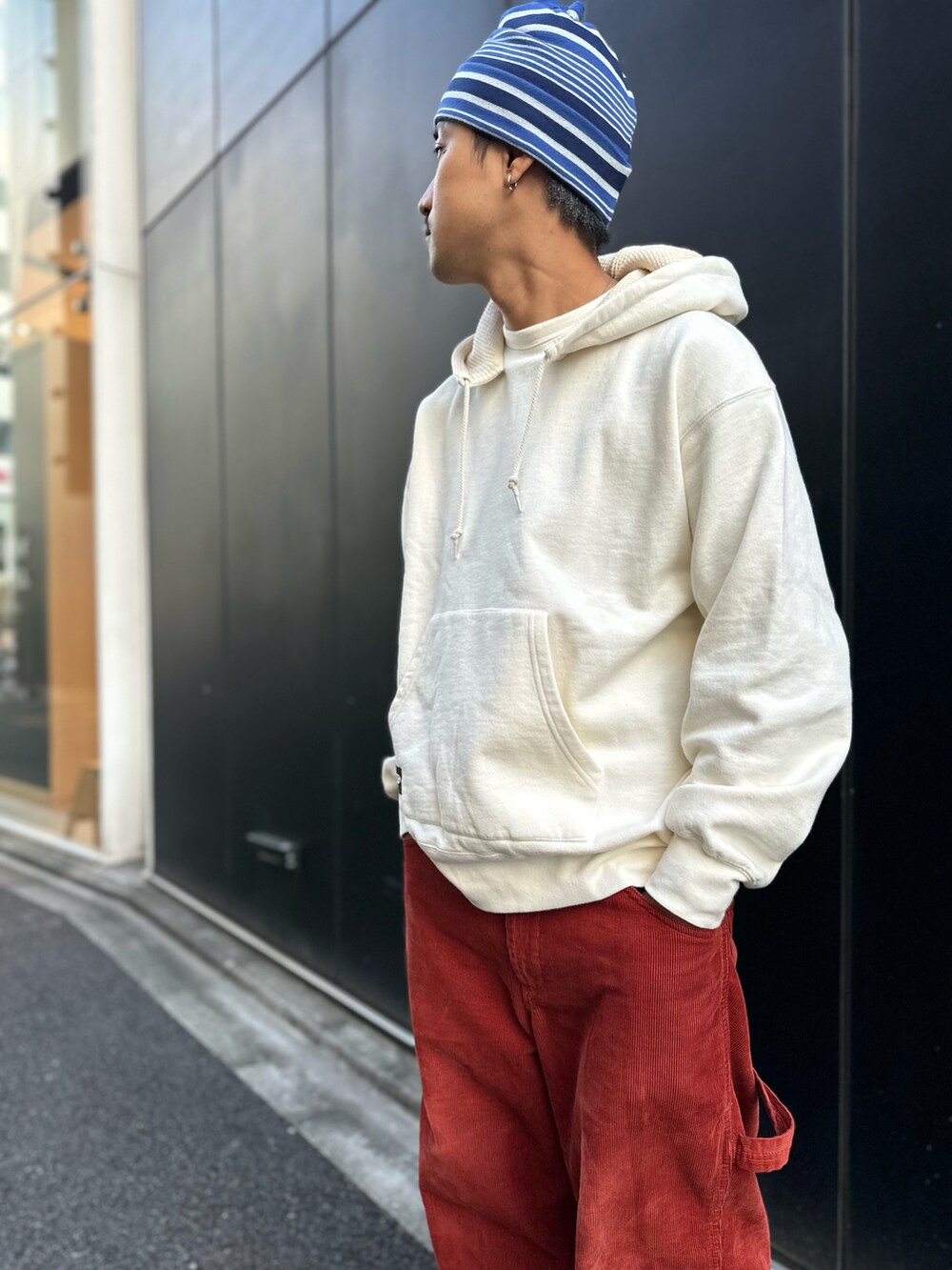 ベージュ系のパーカー、オレンジ系のその他パンツ、ブラック系のスリッポンを着用したメンズの秋コーディネートの4枚目の写真