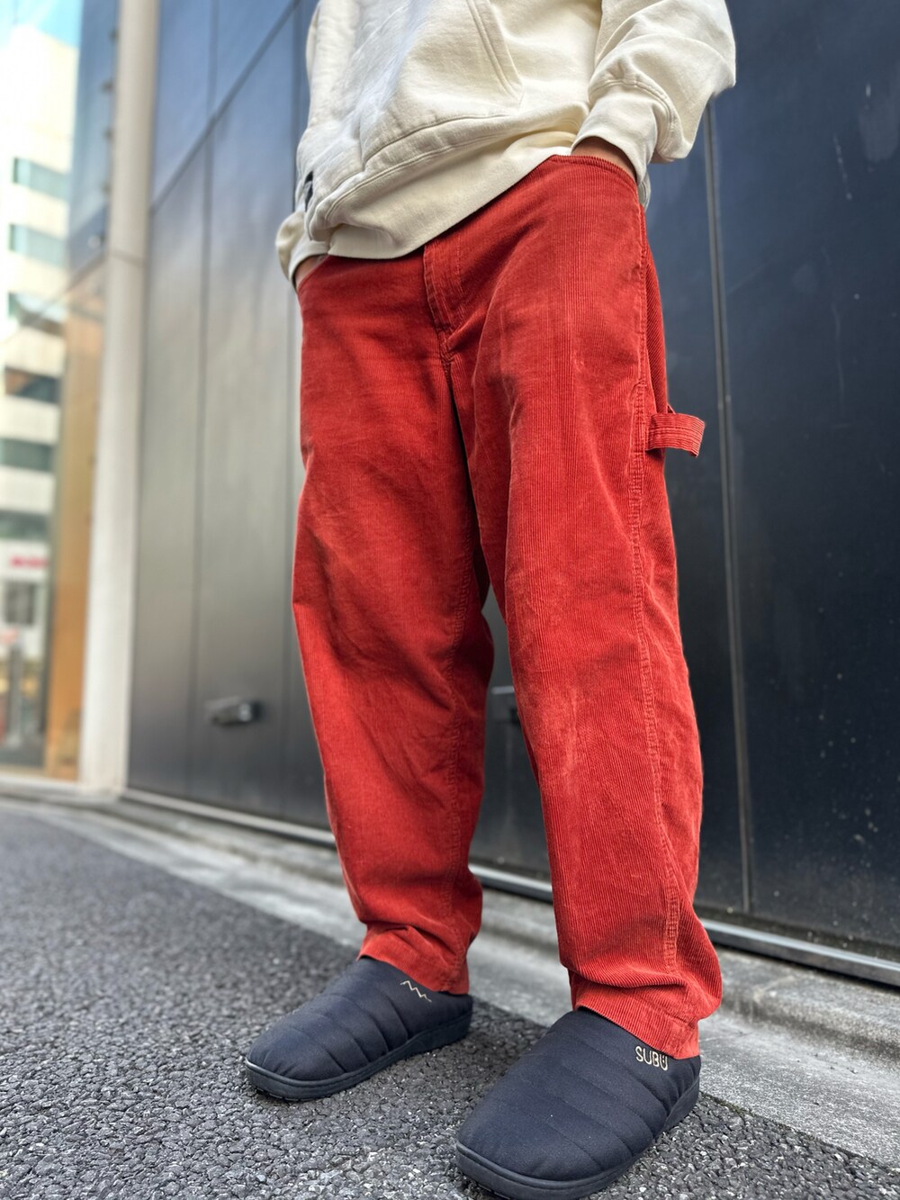 ベージュ系のパーカー、オレンジ系のその他パンツ、ブラック系のスリッポンを着用したメンズの秋コーディネートの5枚目の写真