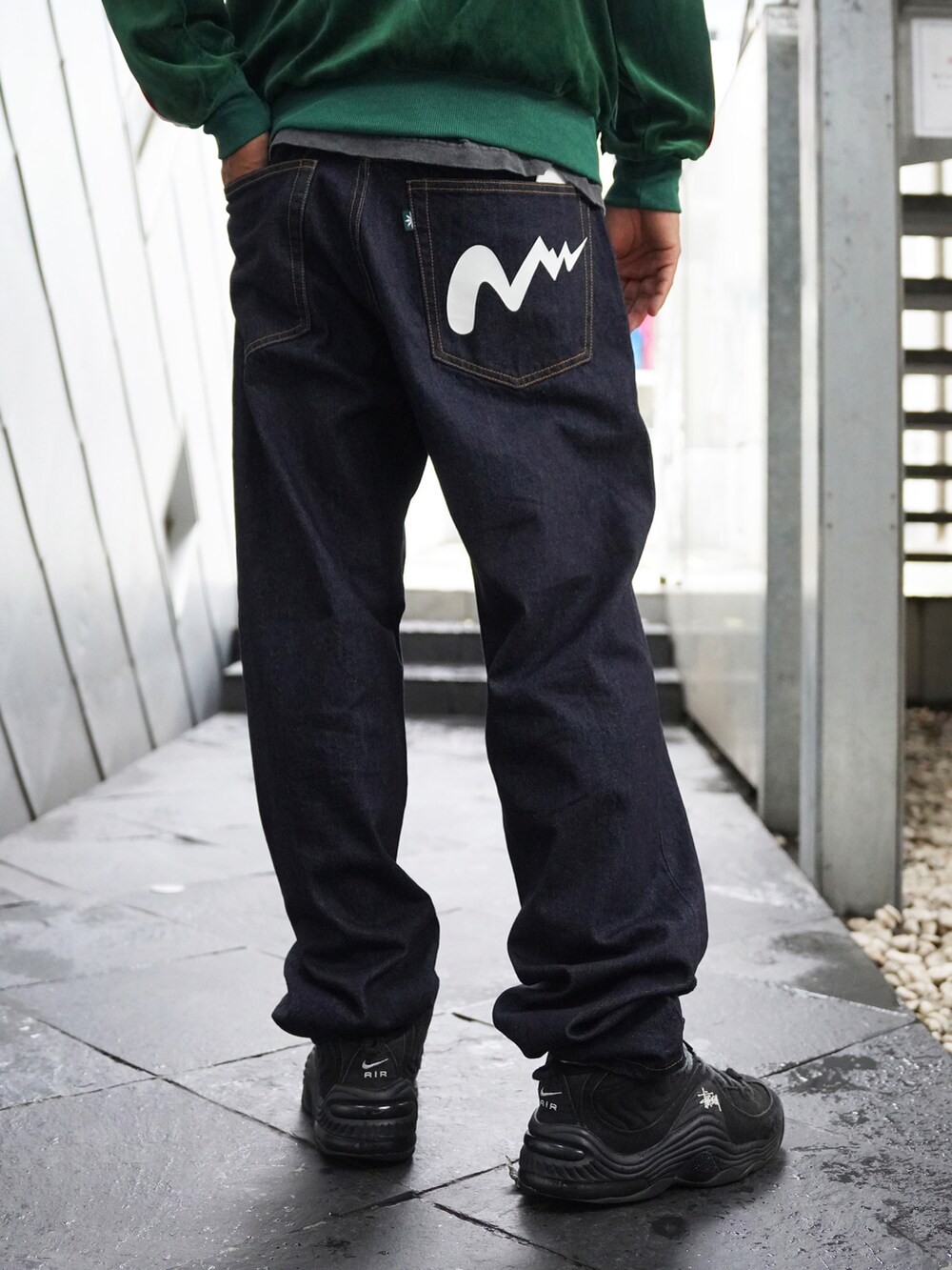 グリーン系のブルゾン、ブルー系のデニムパンツを着用したメンズの夏コーディネートの4枚目の写真