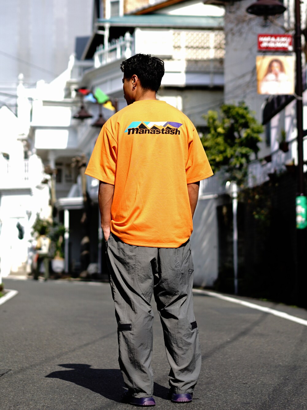 オレンジ系のTシャツ/カットソー、グレー系のその他パンツを着用したメンズの冬コーディネートの4枚目の写真