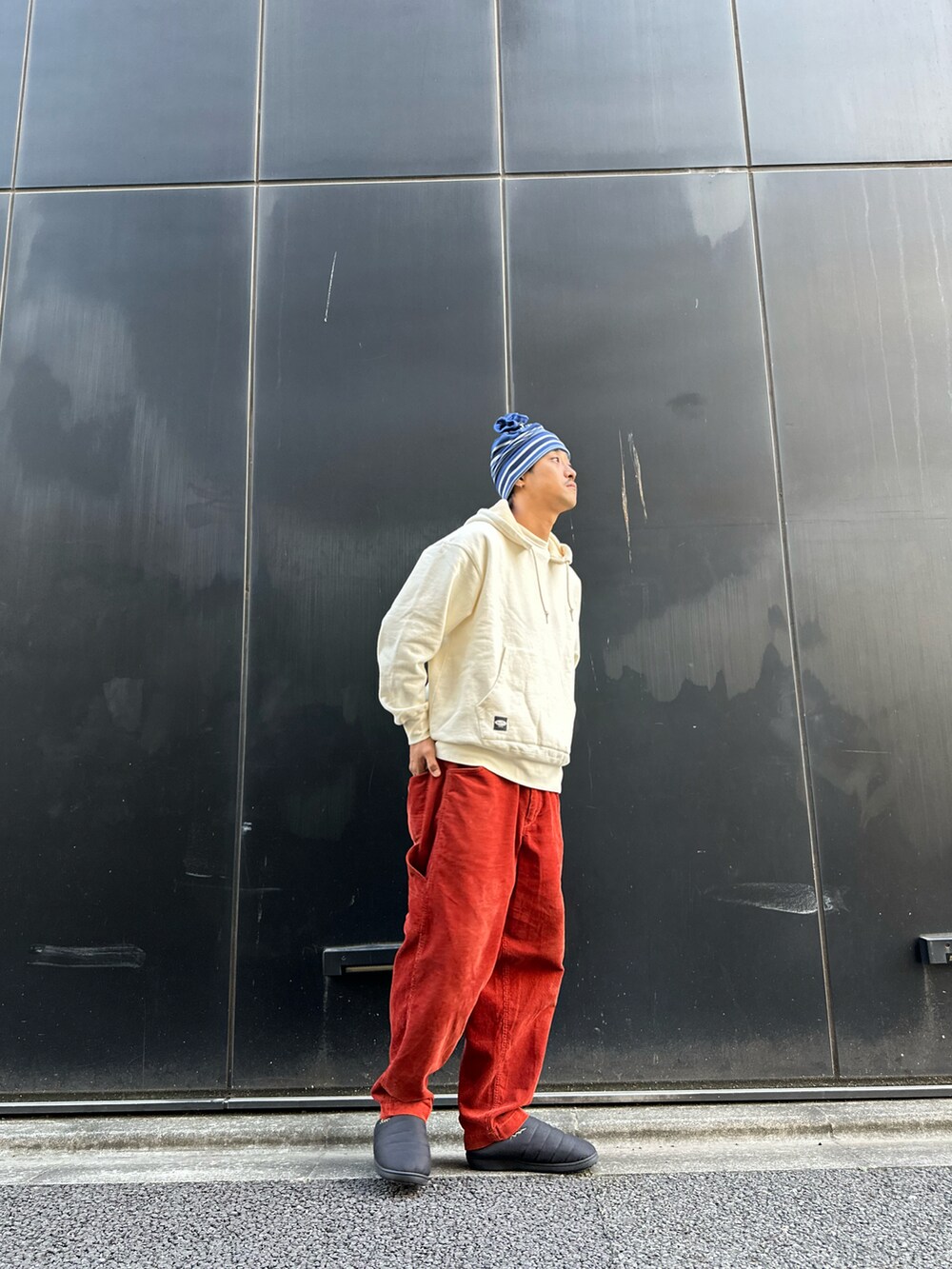 ベージュ系のパーカー、オレンジ系のその他パンツ、ブラック系のスリッポンを着用したメンズの秋コーディネートの3枚目の写真