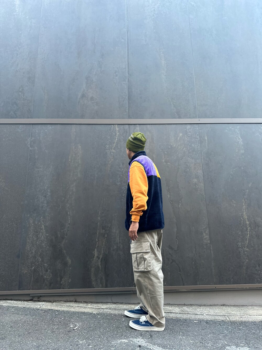 オレンジ系のスウェット、グレー系のカーゴパンツ、グリーン系のニットキャップ/ビーニーを着用したメンズの秋コーディネートの3枚目の写真