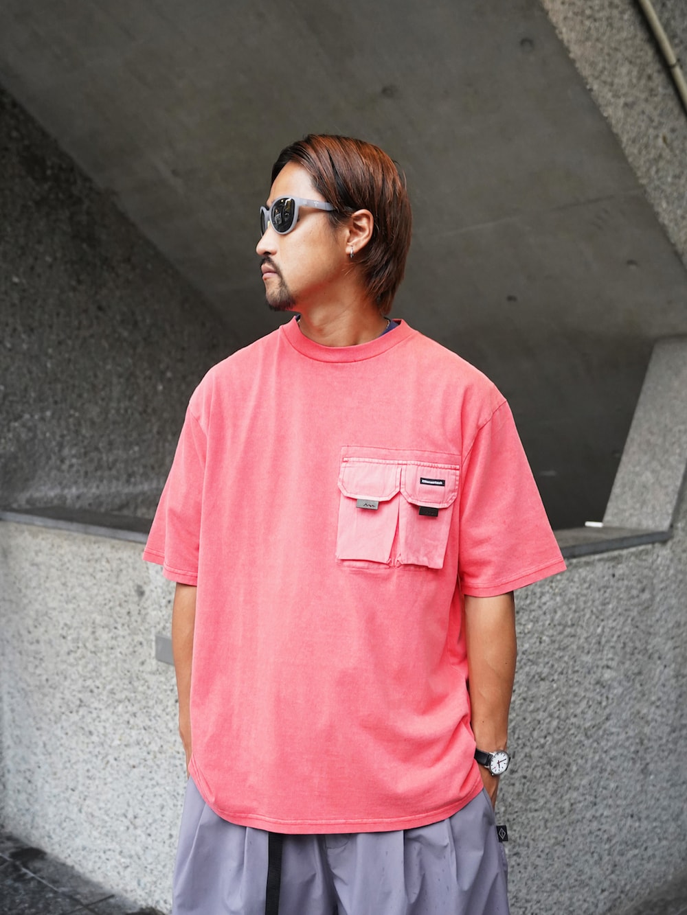 レッド系のTシャツ/カットソー、グレー系のその他パンツ、グレー系のサングラスを着用したメンズの夏コーディネートの2枚目の写真