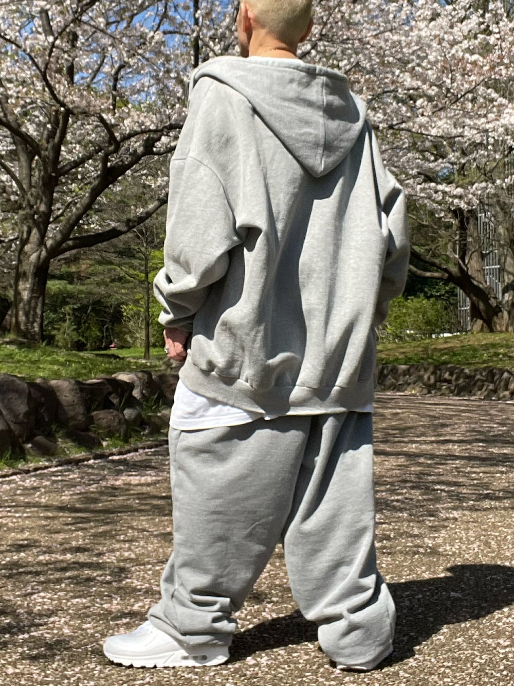 グレー系のセットアップ、ホワイト系のTシャツ/カットソー、ホワイト系のタンクトップを着用したメンズの春コーディネートの2枚目の写真