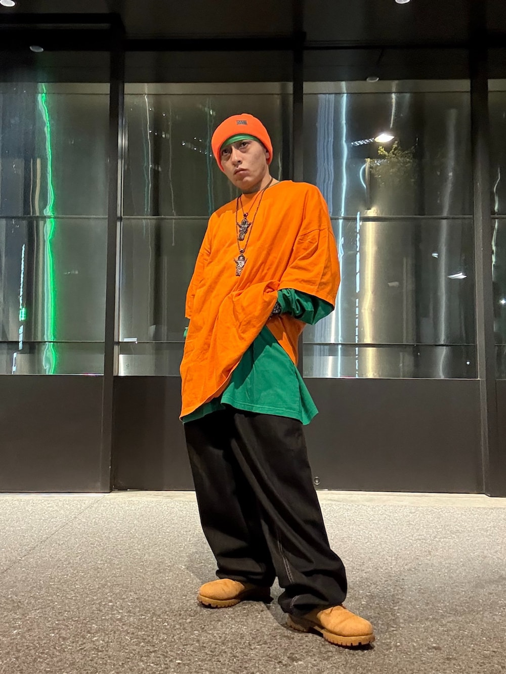 オレンジ系のTシャツ/カットソー、グリーン系のTシャツ/カットソー、ホワイト系のタンクトップを着用したメンズの秋コーディネートの2枚目の写真