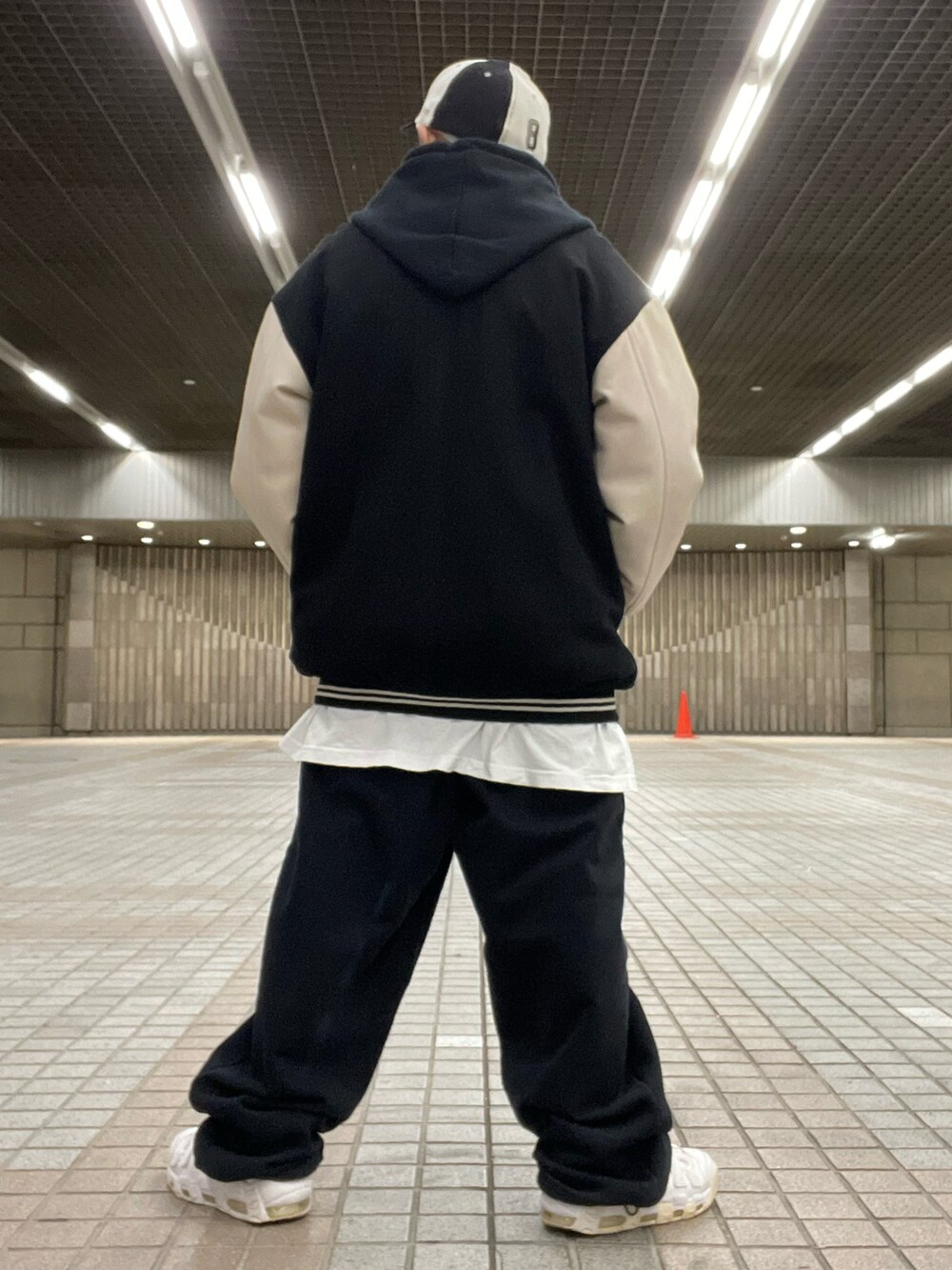 ブラック系のスタジャン、ブラック系のセットアップ、ホワイト系のTシャツ/カットソーを着用したメンズの冬コーディネートの2枚目の写真