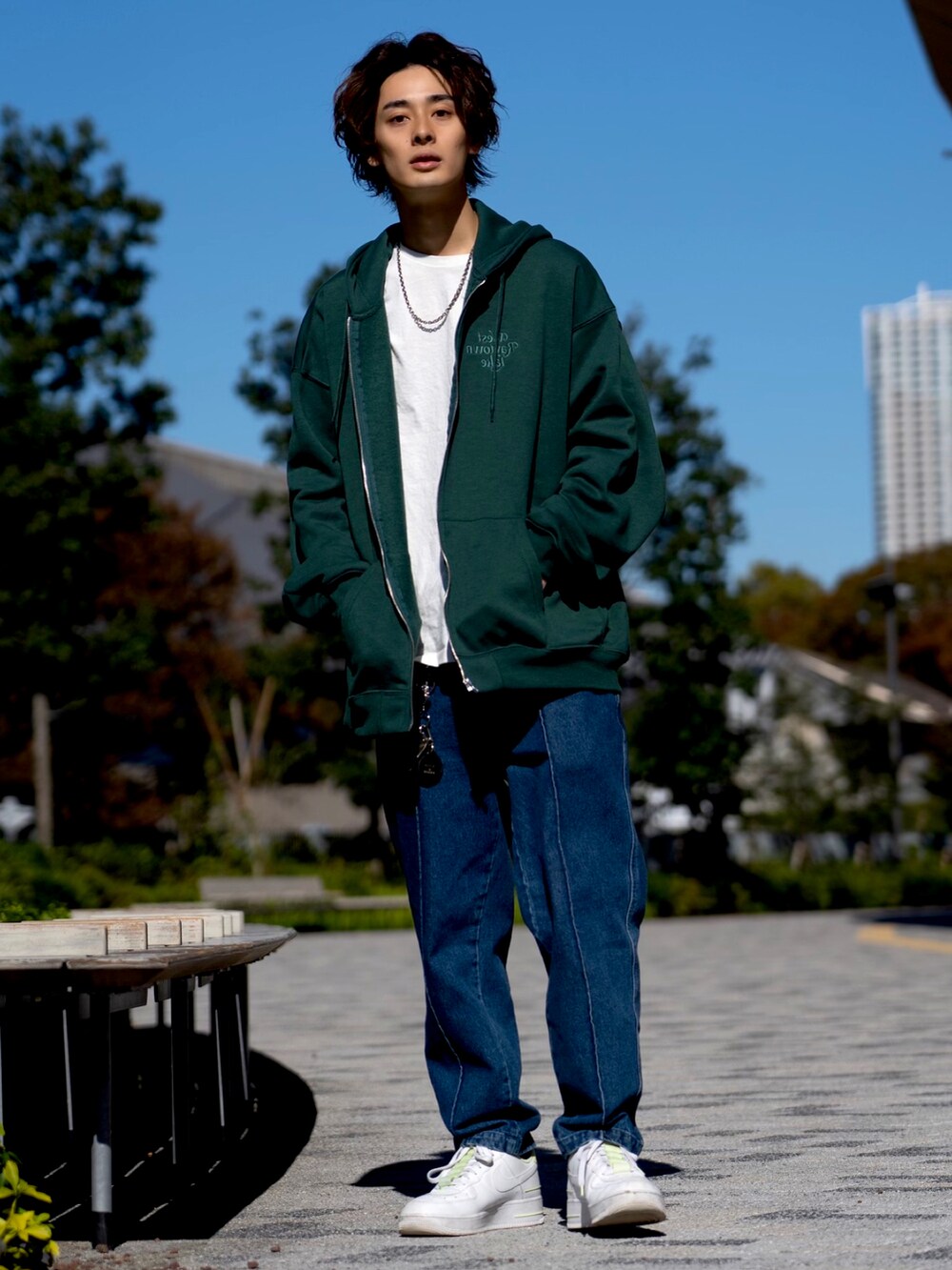 ブルー系のデニムパンツ、ブラック系のスタジャン、グリーン系のパーカーを着用したメンズの秋コーディネートの2枚目の写真