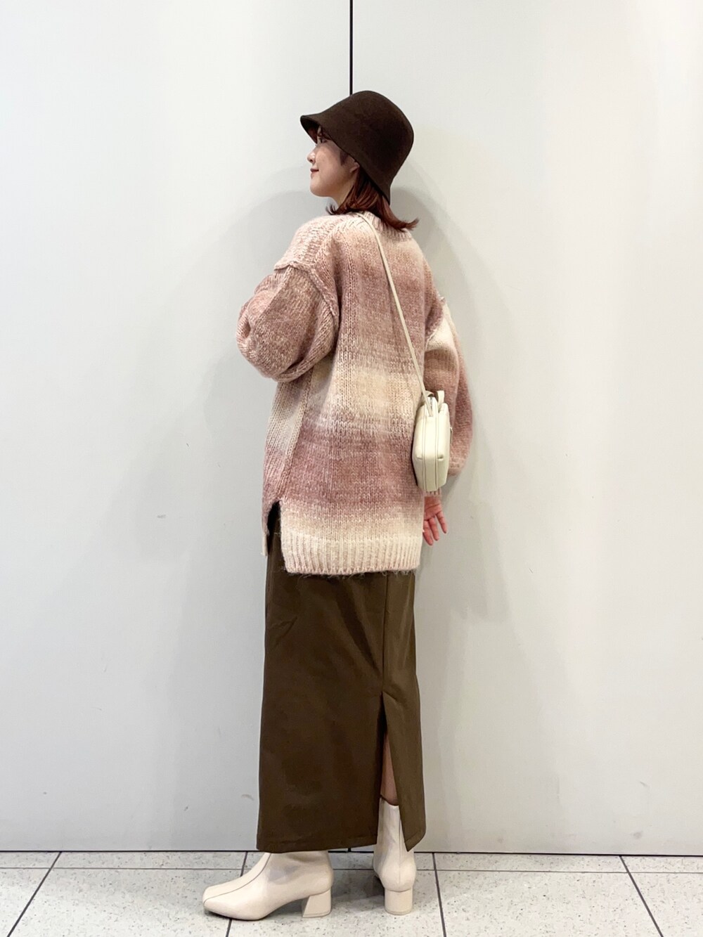 ホワイト系のブーツ、ブラウン系のスカート、ピンク系のニット/セーターを着用したレディースの秋コーディネートの3枚目の写真