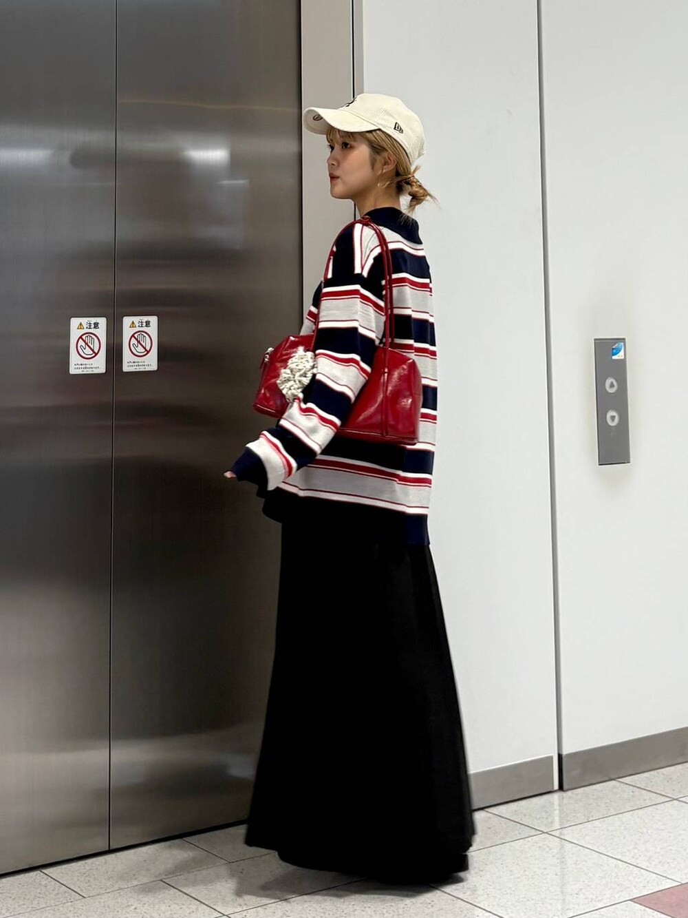 グレー系のスカート、ブルー系のニット/セーター、ブラック系のローファーを着用したレディースの秋コーディネートの4枚目の写真