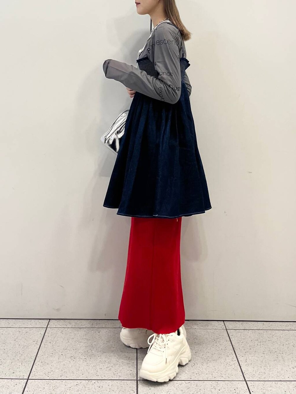 グレー系のTシャツ/カットソー、レッド系のスカート、ホワイト系のスニーカーを着用したレディースの春コーディネートの3枚目の写真