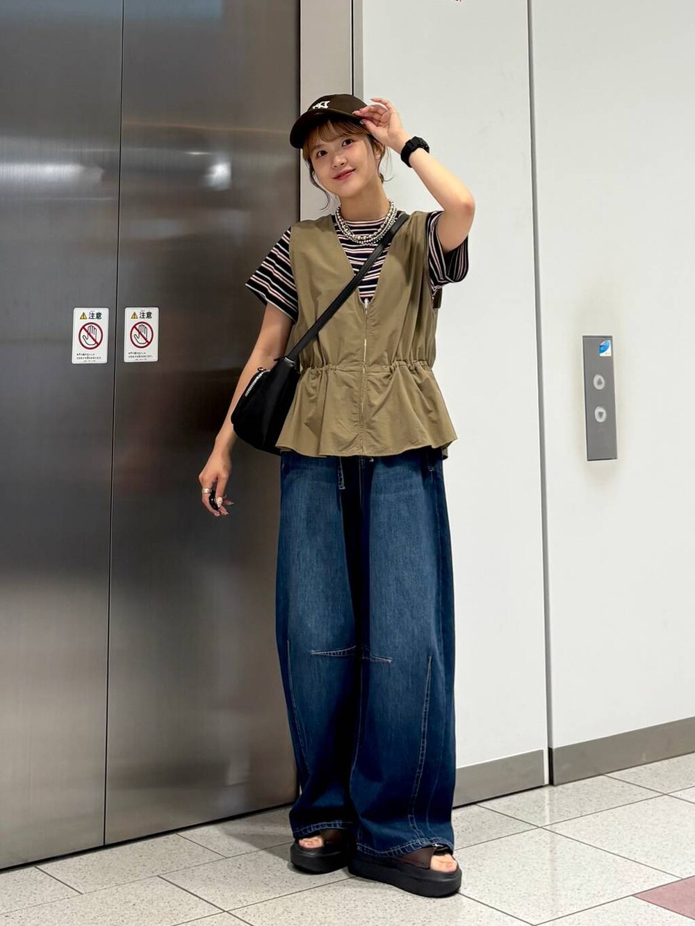 ブルー系のTシャツ/カットソー、ブルー系のデニムパンツ、ブラウン系のサンダルを着用したレディースの夏コーディネートの2枚目の写真