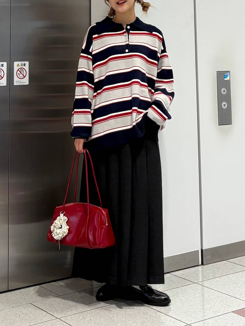 グレー系のスカート、ブルー系のニット/セーター、ブラック系のローファーを着用したレディースの秋コーディネートの2枚目の写真