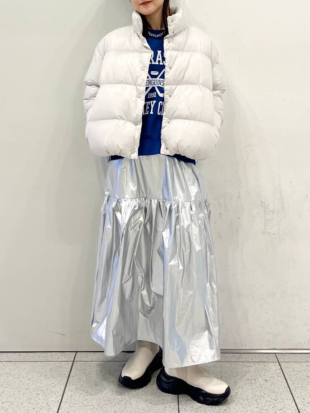 ブルー系のスウェット、ホワイト系のブルゾン、ホワイト系のブーツを着用したレディースの冬コーディネートの2枚目の写真