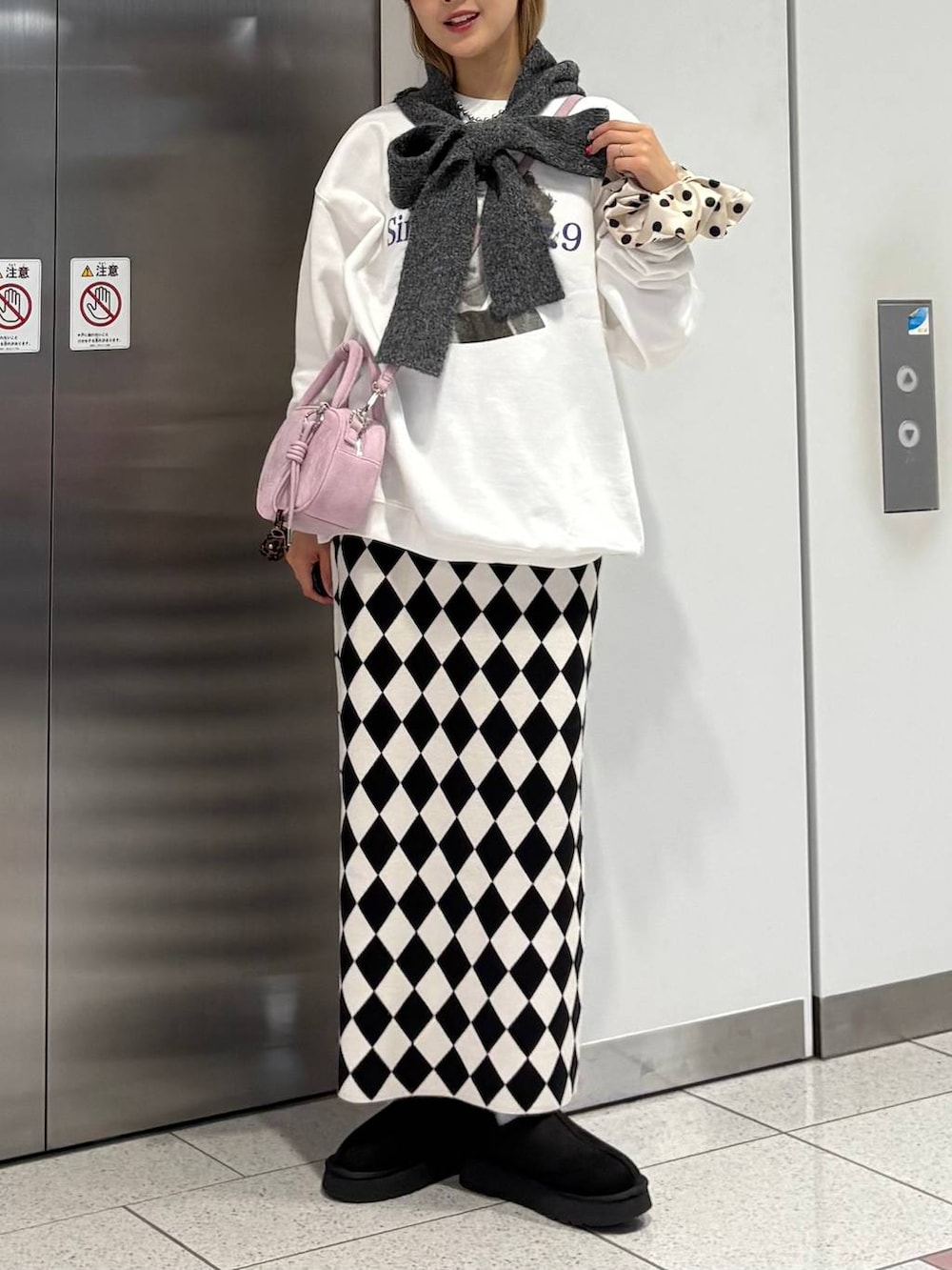 その他のスカート、ブラック系のその他シューズ、ピンク系のボストンバッグを着用したレディースの冬コーディネートの3枚目の写真