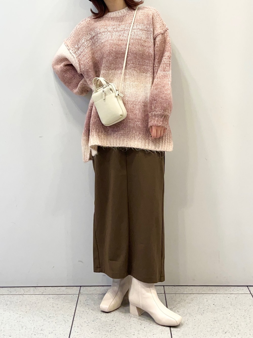 ホワイト系のブーツ、ブラウン系のスカート、ピンク系のニット/セーターを着用したレディースの秋コーディネートの2枚目の写真