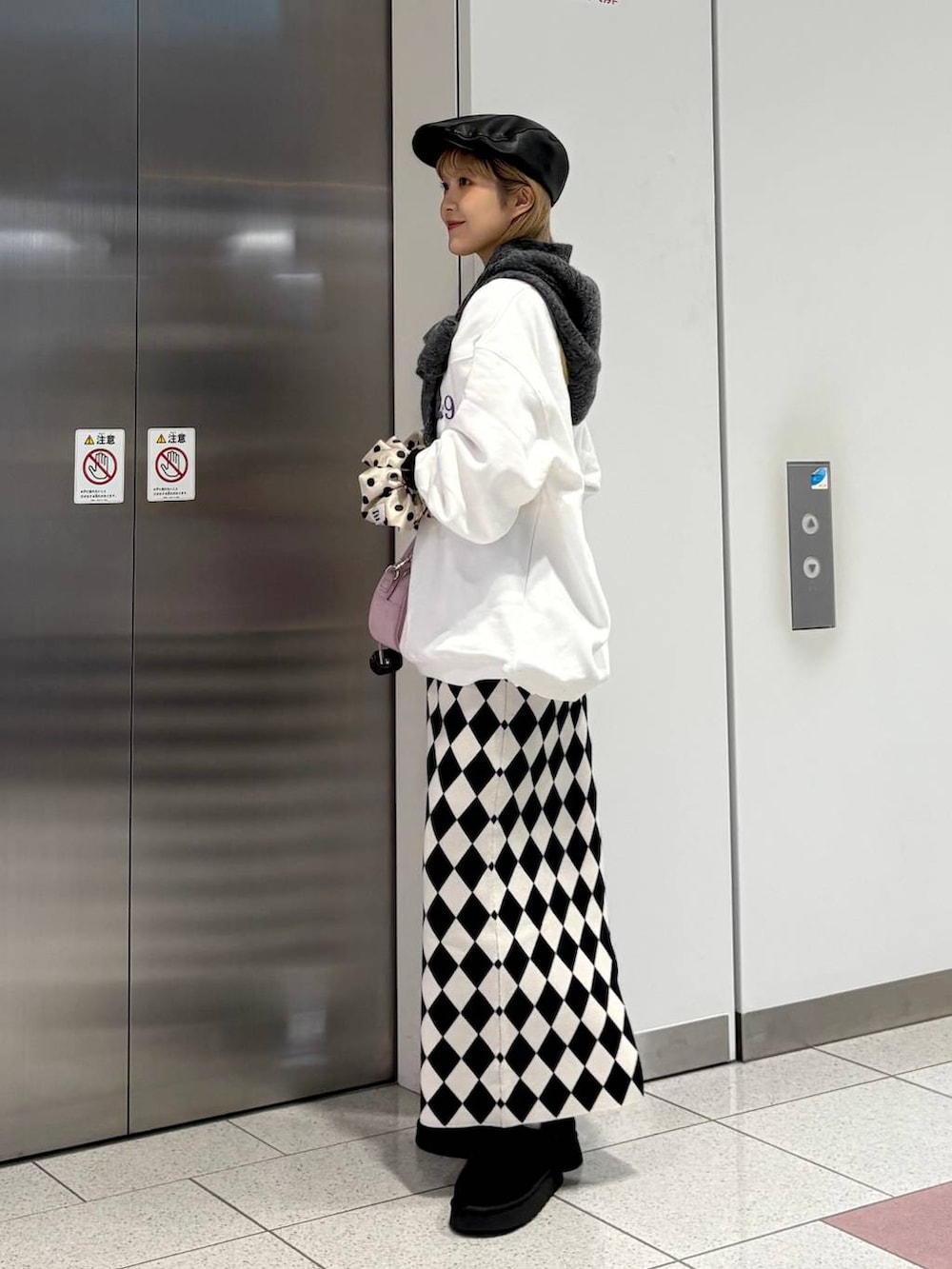 その他のスカート、ブラック系のその他シューズ、ピンク系のボストンバッグを着用したレディースの冬コーディネートの4枚目の写真