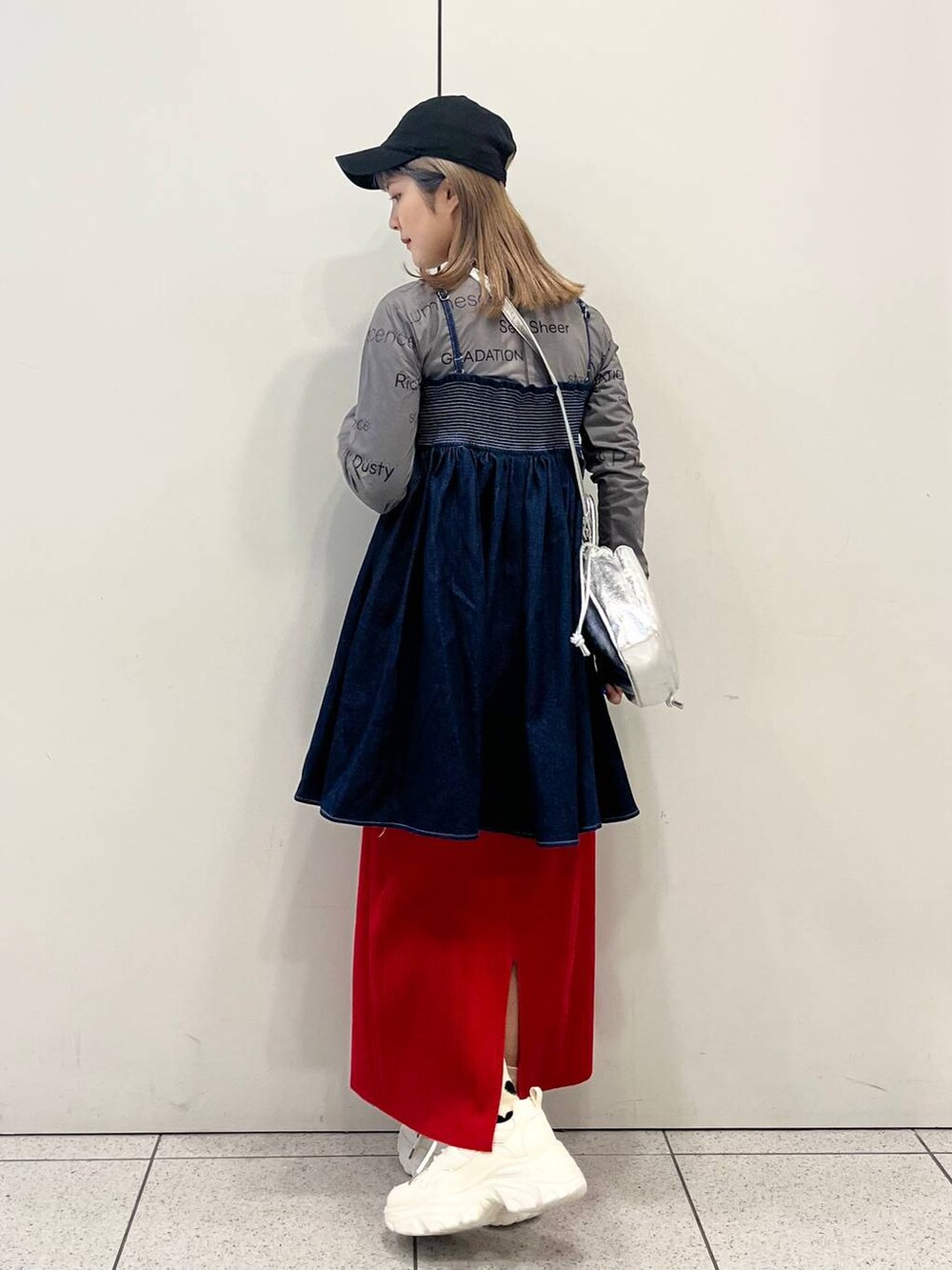 グレー系のTシャツ/カットソー、レッド系のスカート、ホワイト系のスニーカーを着用したレディースの春コーディネートの4枚目の写真