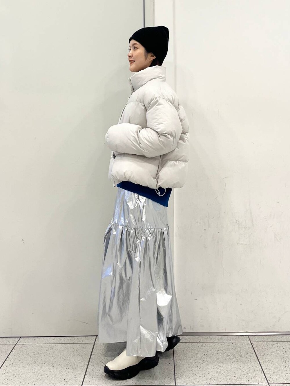 ブルー系のスウェット、ホワイト系のブルゾン、ホワイト系のブーツを着用したレディースの冬コーディネートの3枚目の写真