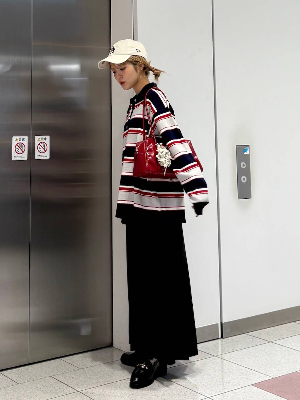 グレー系のスカート、ブルー系のニット/セーター、ブラック系のローファーを着用したレディースの秋コーディネートの5枚目の写真