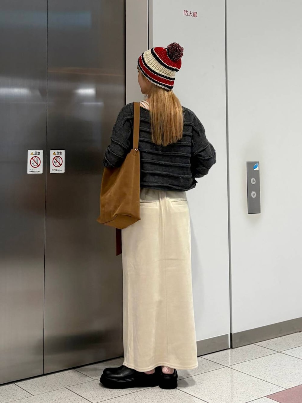 ホワイト系のスカート、ブラック系のサンダル、ベージュ系のショルダーバッグを着用したレディースの秋コーディネートの4枚目の写真