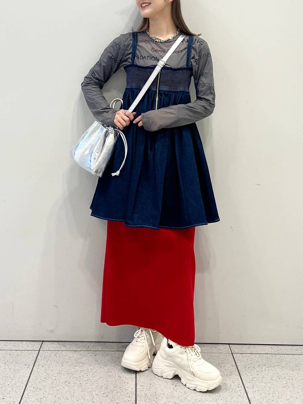 グレー系のTシャツ/カットソー、レッド系のスカート、ホワイト系のスニーカーを着用したレディースの春コーディネートの2枚目の写真