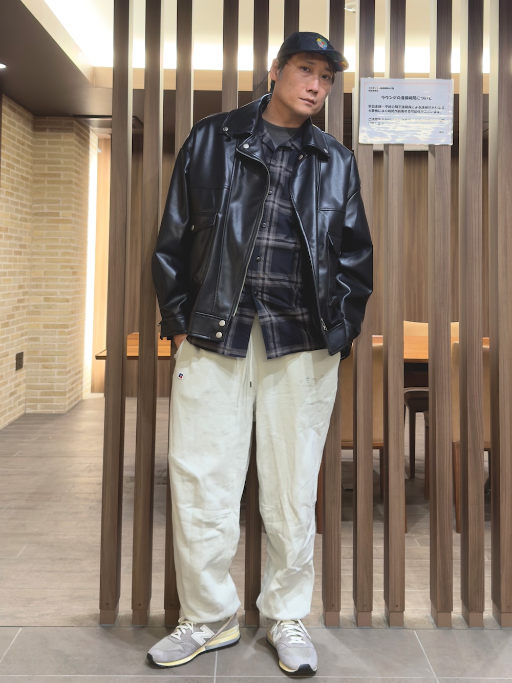 ブラック系のライダースジャケット、ブラック系のTシャツ/カットソー、ホワイト系のスウェットパンツを着用したメンズの秋コーディネートの2枚目の写真