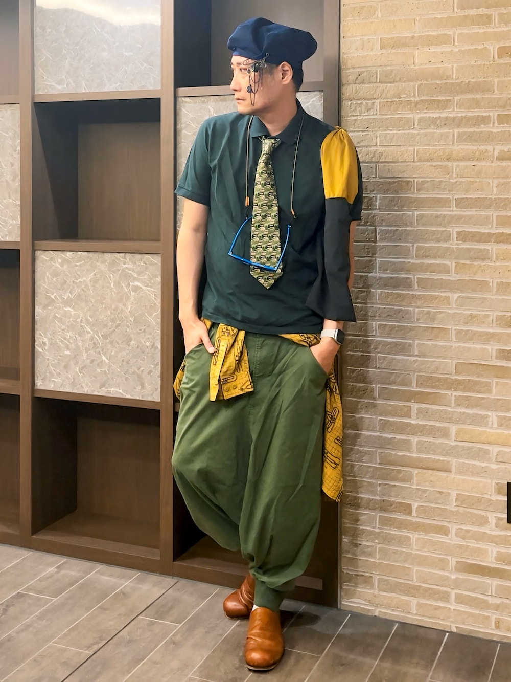 グリーン系のポロシャツ、グリーン系のその他パンツ、その他のトートバッグを着用したメンズの夏コーディネートの2枚目の写真