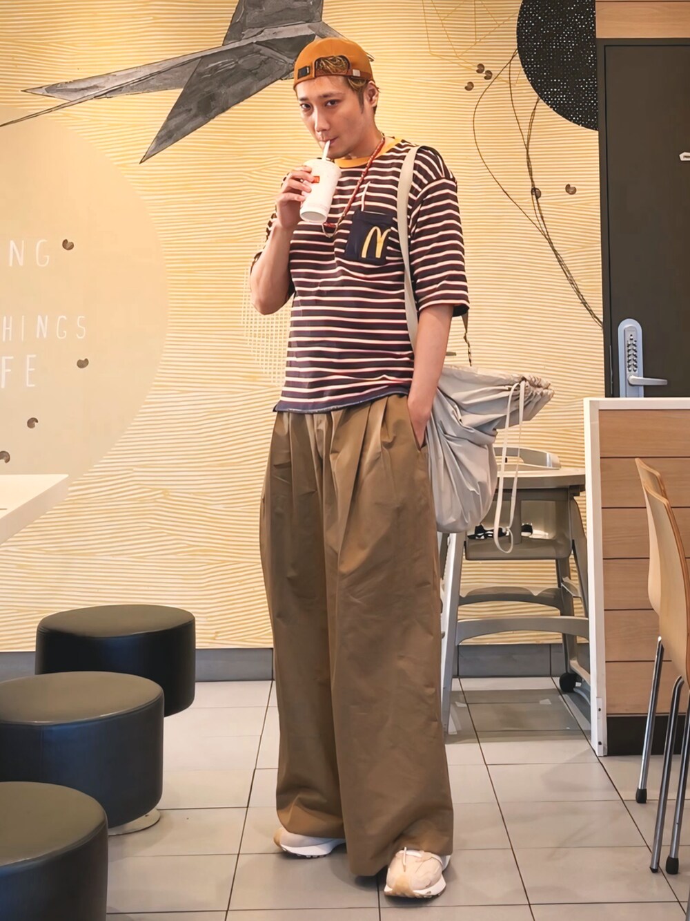 ブルー系のTシャツ/カットソー、ホワイト系のショルダーバッグ、ブラウン系のパンツを着用したメンズの秋コーディネートの2枚目の写真