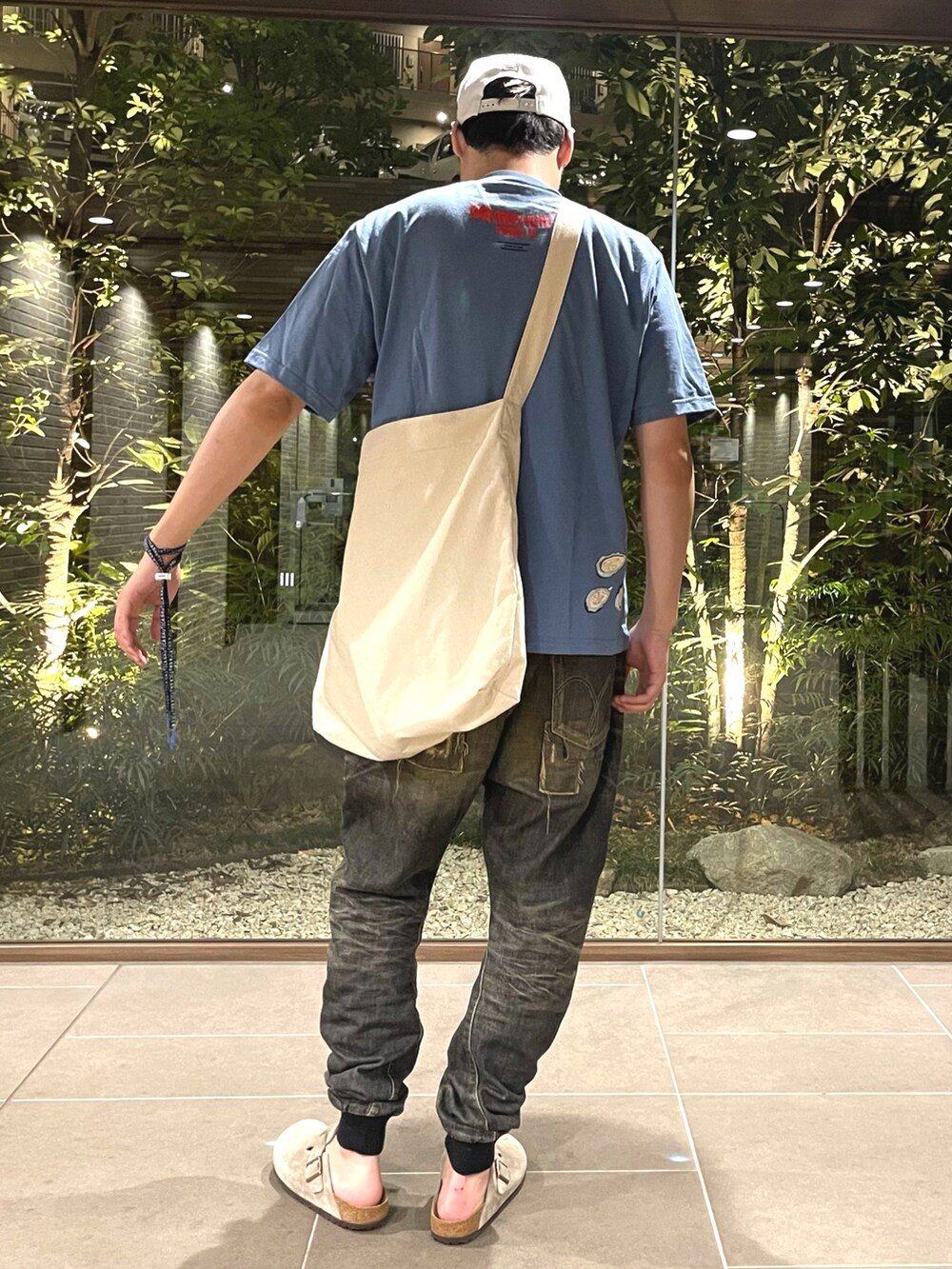 ブルー系のTシャツ/カットソー、ブラック系のデニムパンツ、ベージュ系のサンダルを着用したメンズの夏コーディネートの3枚目の写真