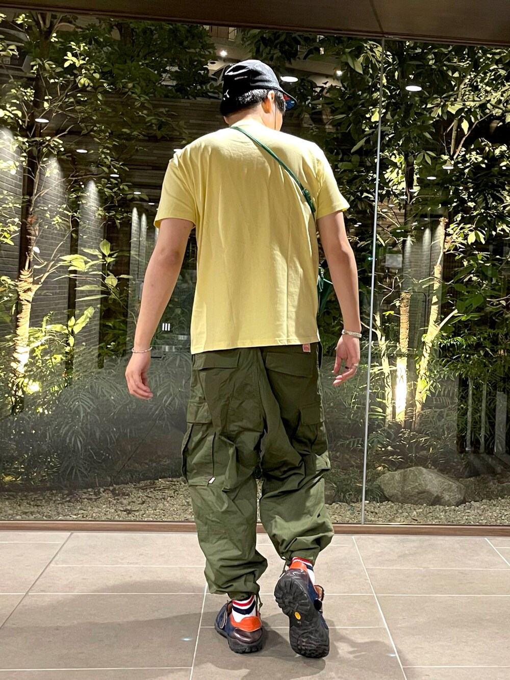 イエロー系のTシャツ/カットソー、グリーン系のショルダーバッグ、グリーン系のカーゴパンツを着用したメンズの夏コーディネートの4枚目の写真
