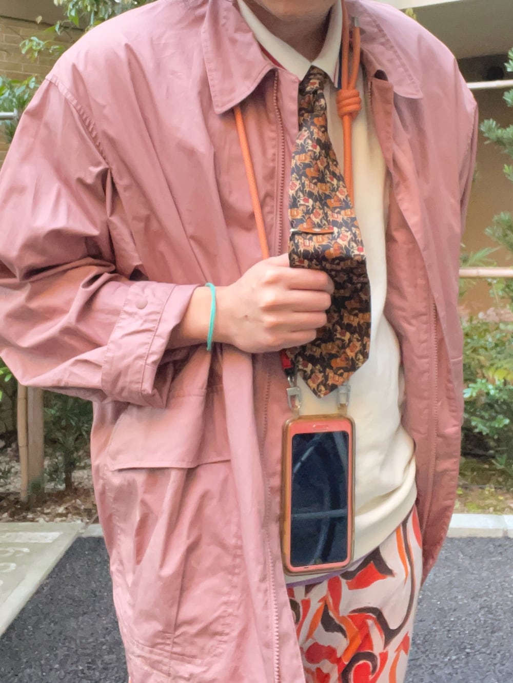 ホワイト系のポロシャツ、ピンク系のジャケット/アウター、ブラック系のネクタイを着用したメンズの春コーディネートの2枚目の写真