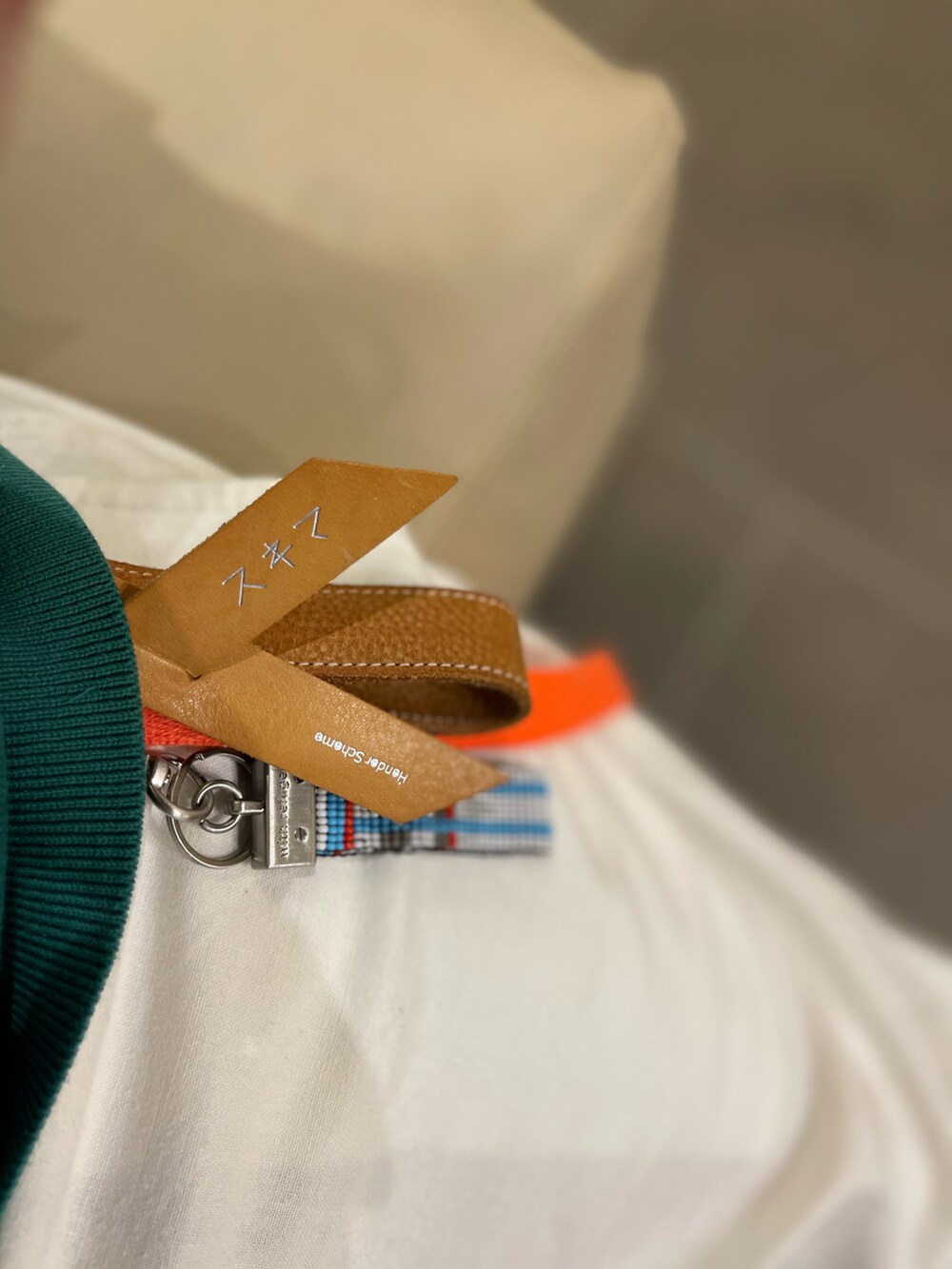 グリーン系のニット/セーター、ピンク系のパーカー、ホワイト系のその他パンツを着用したメンズの春コーディネートの3枚目の写真