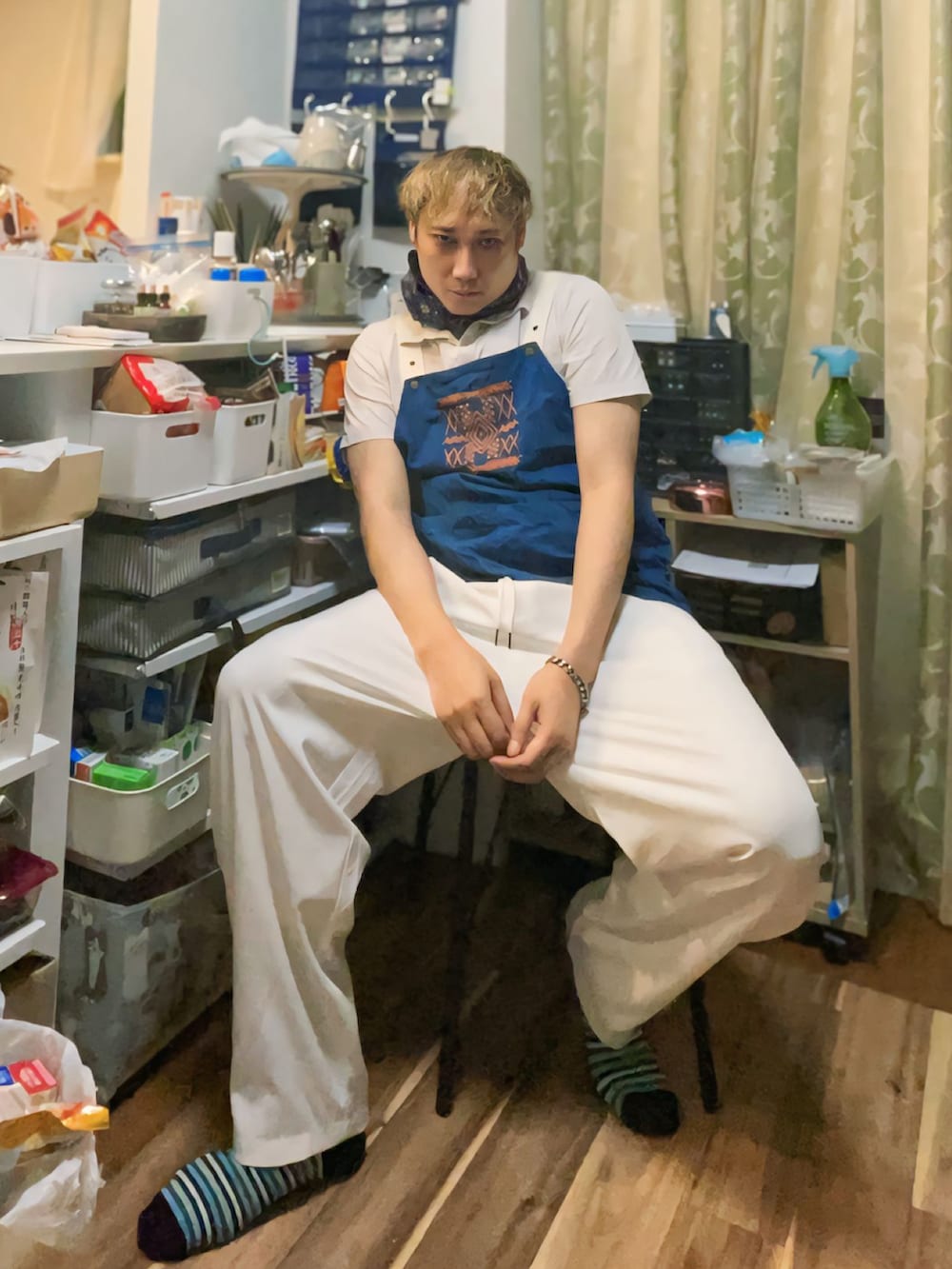 ホワイト系のポロシャツ、ホワイト系のスラックス、ブルー系のブーツを着用したメンズの秋コーディネートの2枚目の写真