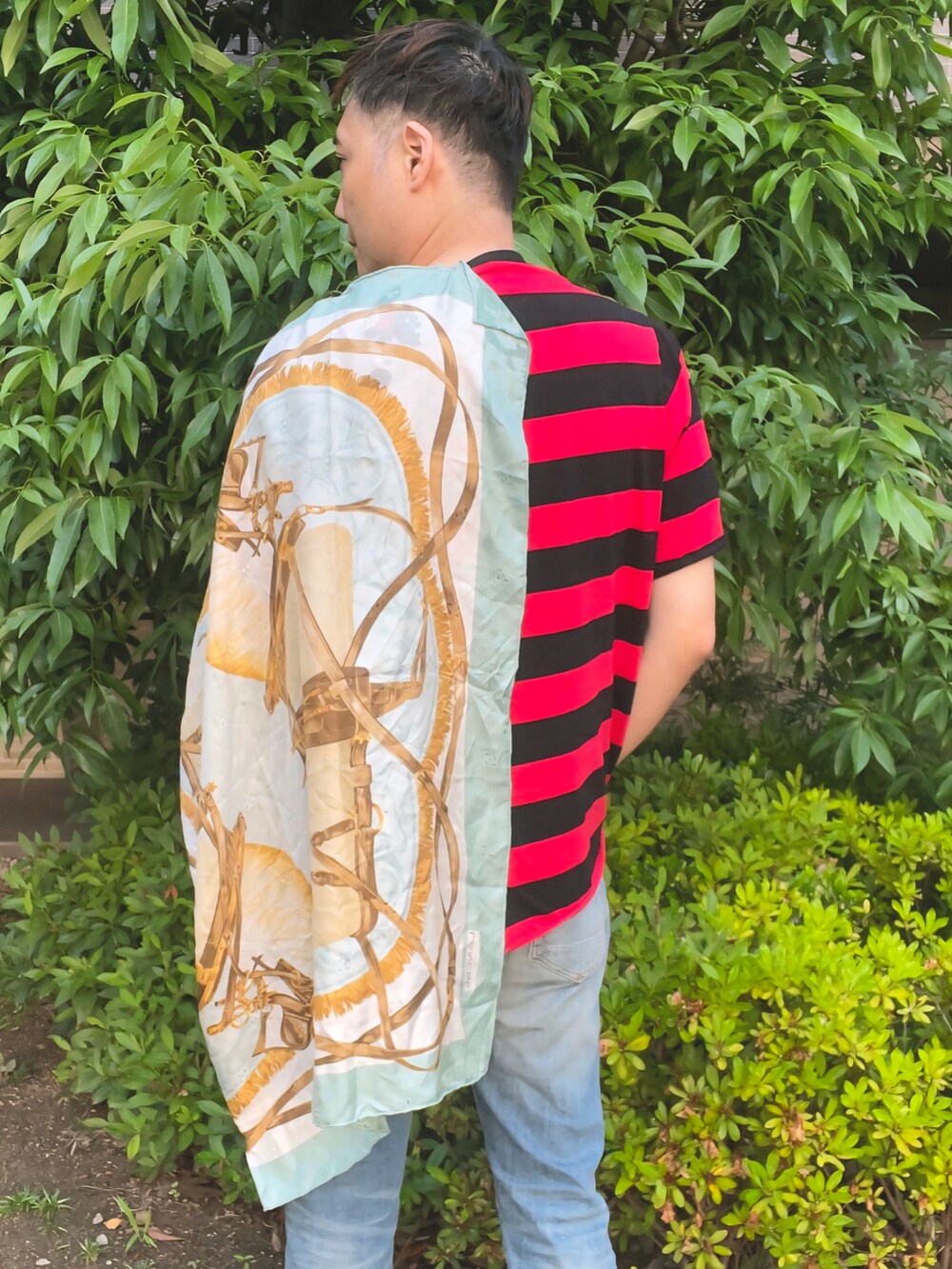ブルー系のデニムパンツ、ベージュ系のブーツ、レッド系のTシャツ/カットソーを着用したメンズの夏コーディネートの4枚目の写真