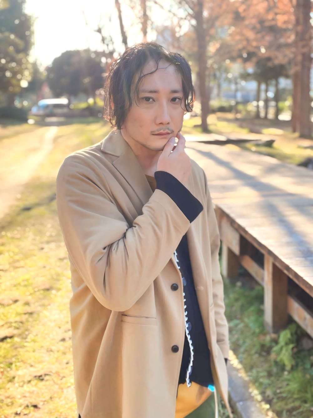 イエロー系のTシャツ/カットソー、ブラック系のカーディガン/ボレロ、ベージュ系のテーラードジャケットを着用したメンズの冬コーディネートの4枚目の写真