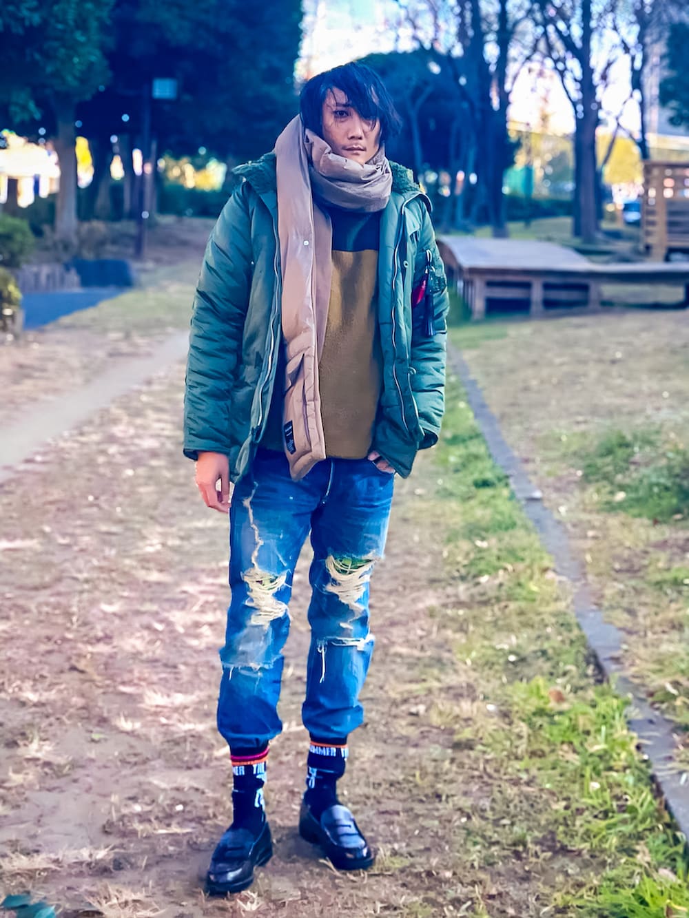 グリーン系のミリタリージャケット、ブルー系のデニムパンツ、ブラウン系のローファーを着用したメンズの冬コーディネートの3枚目の写真